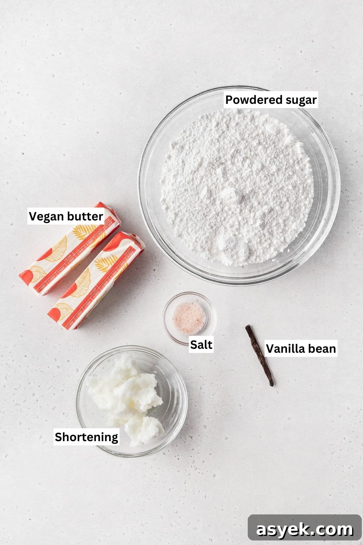 Ingredients for making vegan vanilla buttercream frosting laid out on a white table.