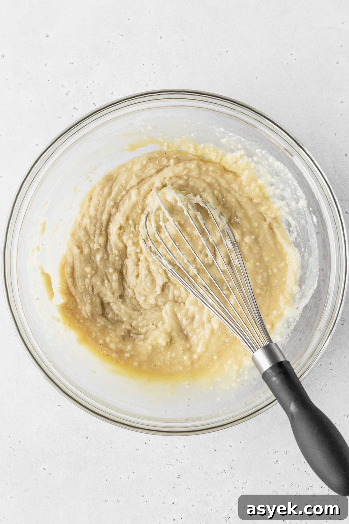 Dry ingredients added to wet ingredients for making dairy-free cupcakes, but the batter is still thick and lumpy because the dairy-free milk is yet to be added.