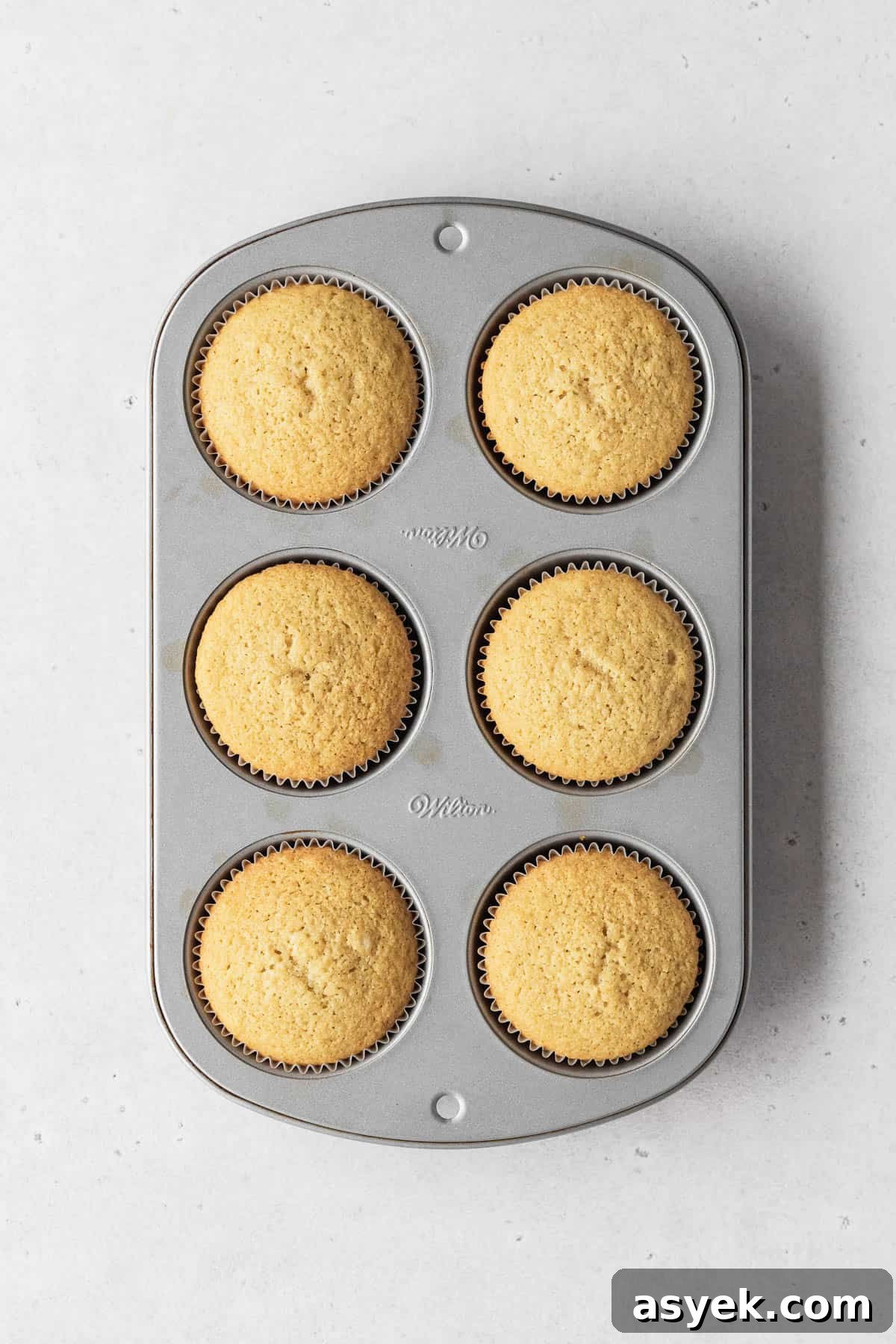 Muffin tin filled with 6 perfectly baked dairy-free vanilla cupcakes.