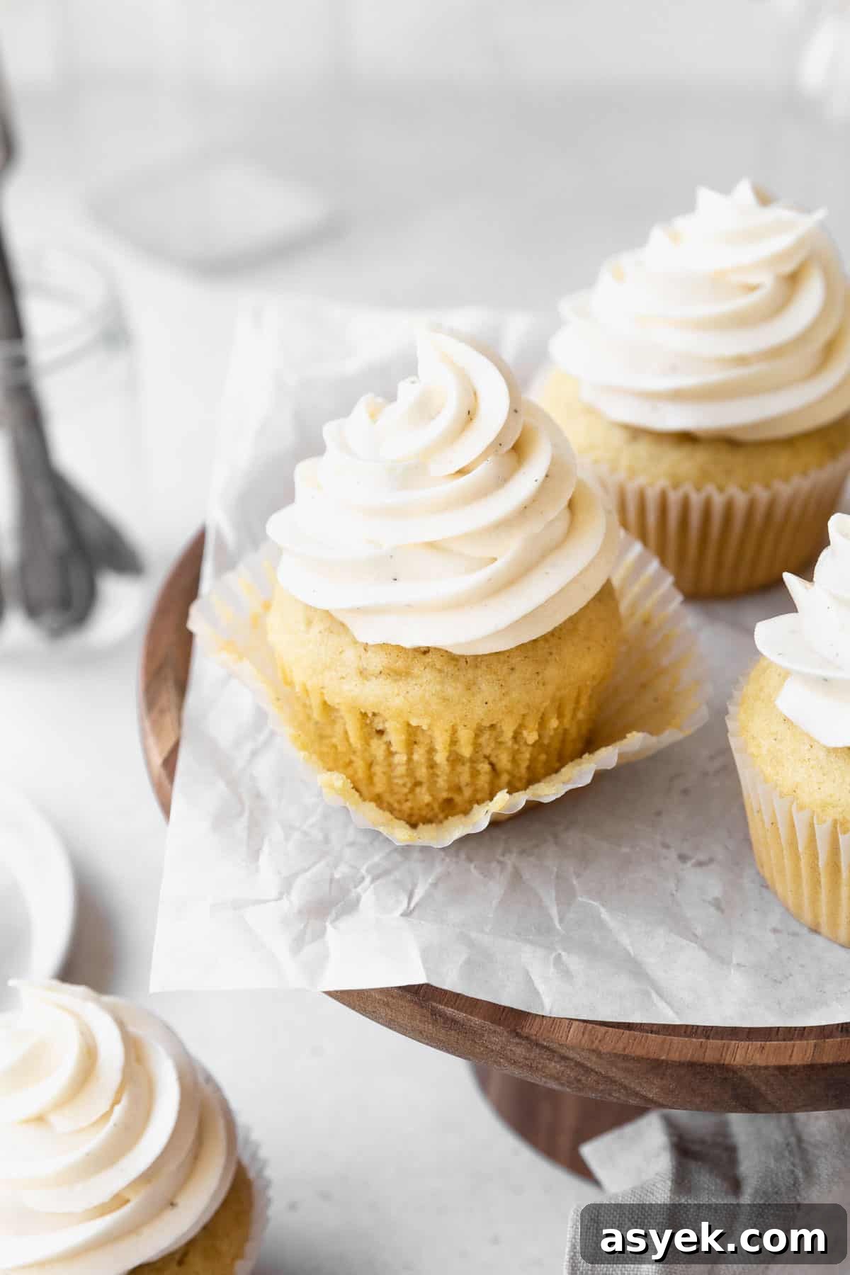 A dairy-free vanilla cupcake with the wrapper pulled off to expose the texture of the cake.
