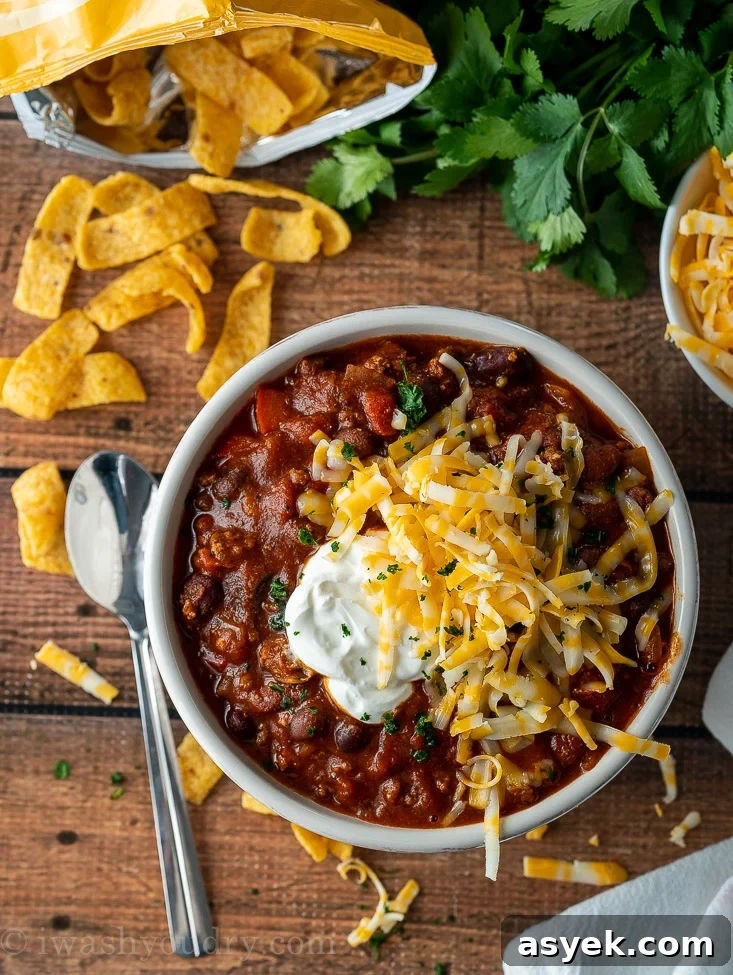Homemade Chili Recipe from Scratch - Authentic Chili Con Carne 7 bowl of chili with spoon and sour cream on top.