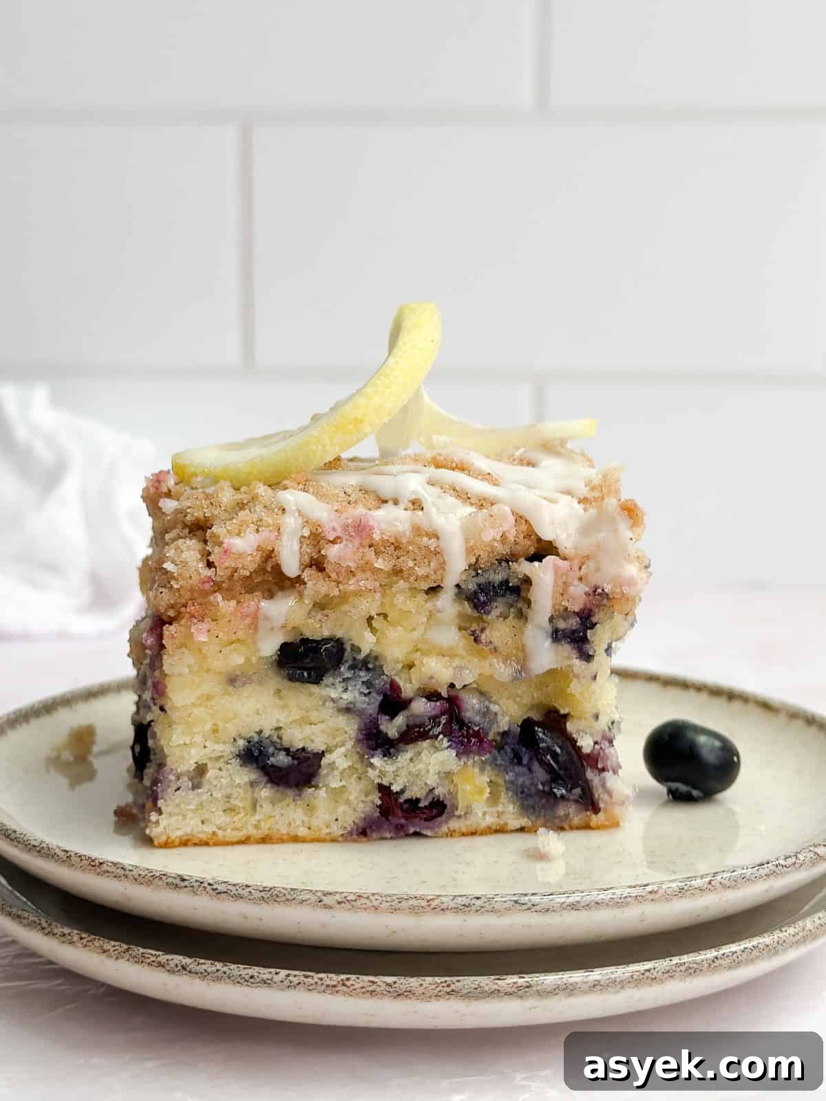 a single slice of blueberry lemon crumb cake on a plate.