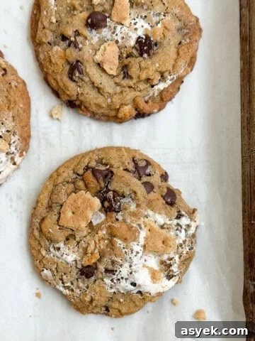 a few of the brown butter s'mores chocolate chip cookies on a baking sheet.