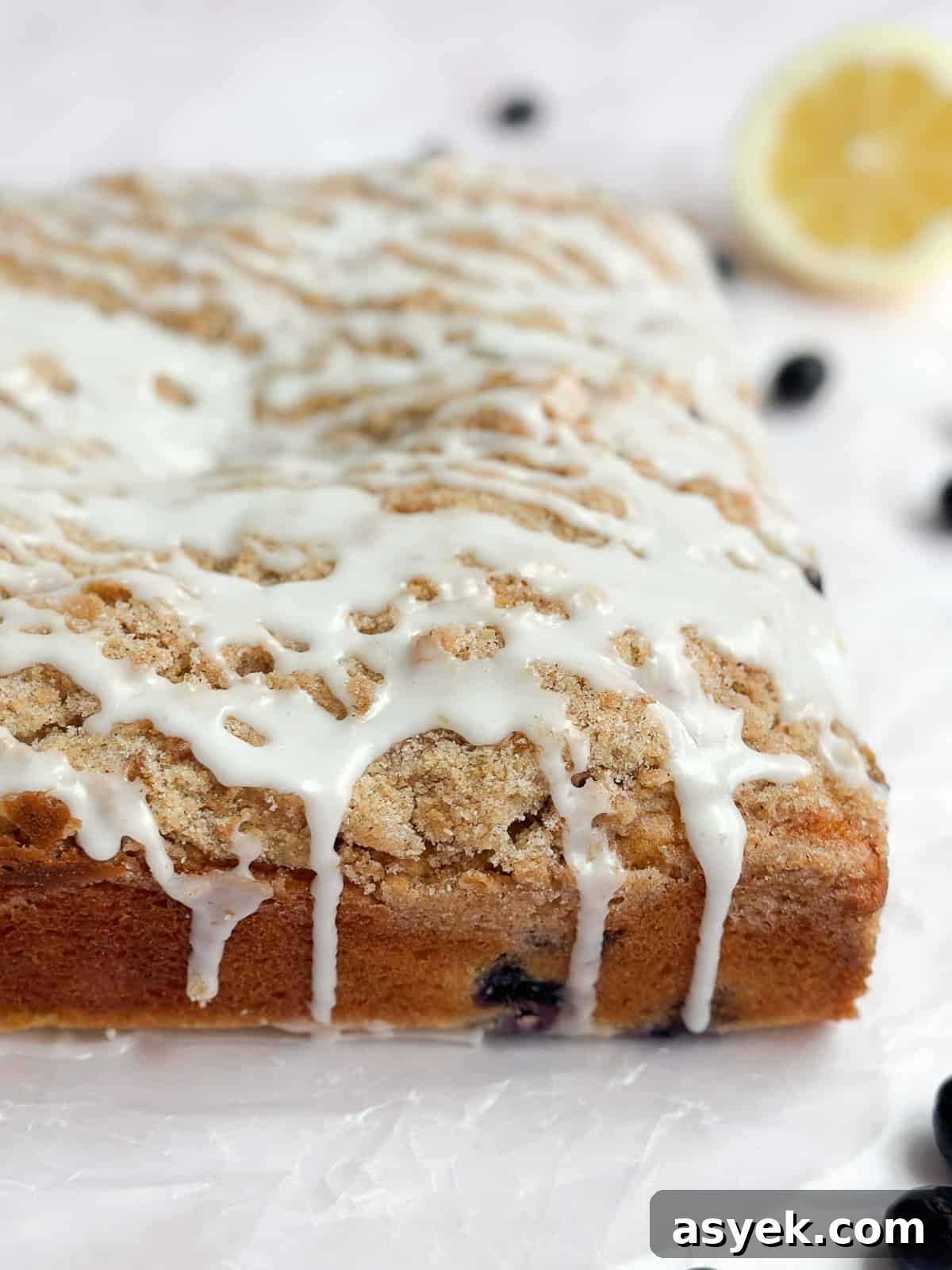 a side view of the lemon glaze drizzling down the cake.