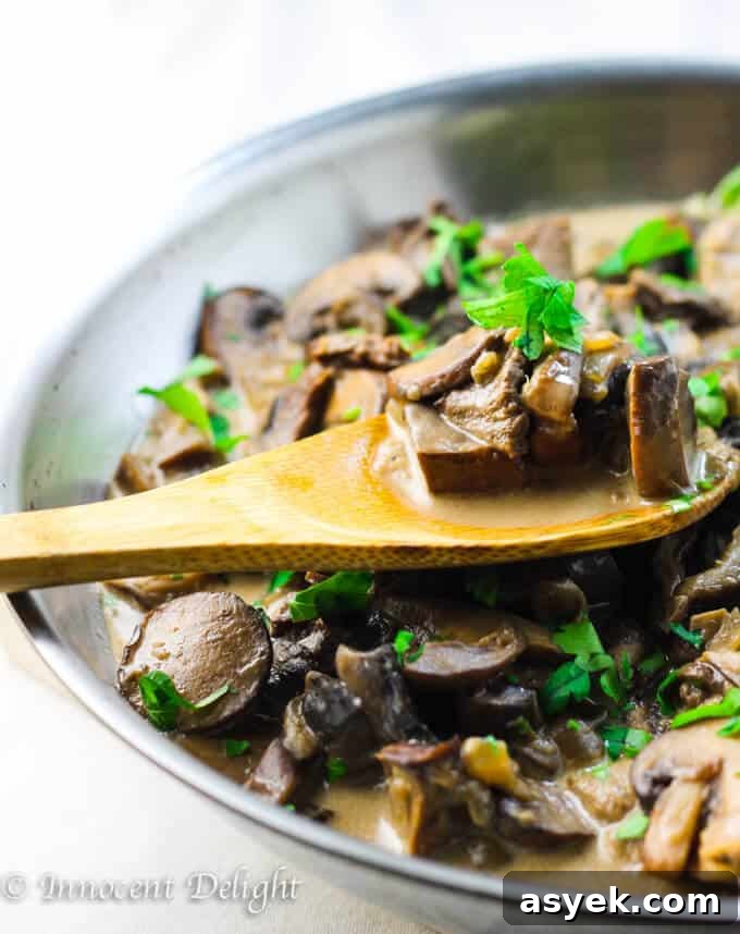 Creamy Mushroom Sauce in skillet with wooden spoon.