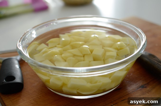 Korean Braised Potatoes (Gamja Jorim) Recipe 3 Cubed potato pieces are soaking in water in a bowl.