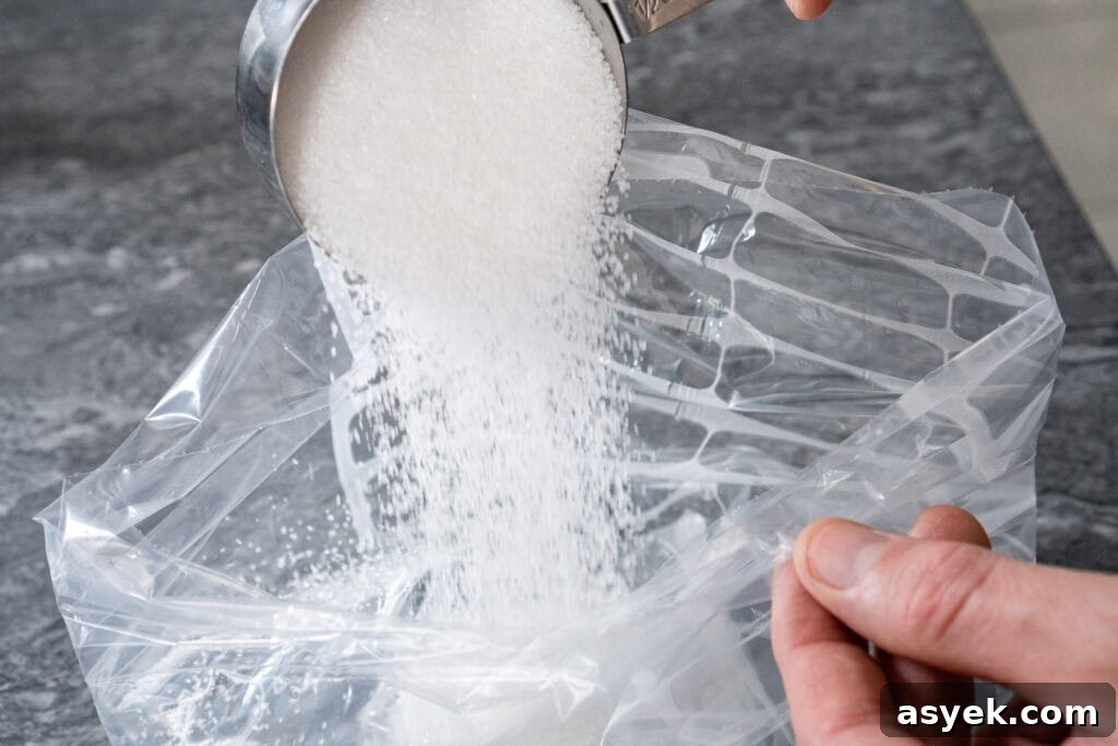 Pouring ½ cup of white granulated sugar into a food bag