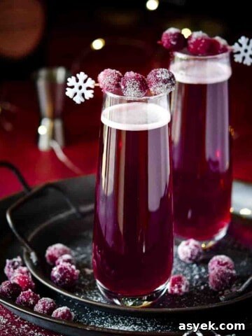 Festive Eggnog White Russian Cocktail Recipe 12 Cranberry mimosas with sugared cranberries on a black tray.