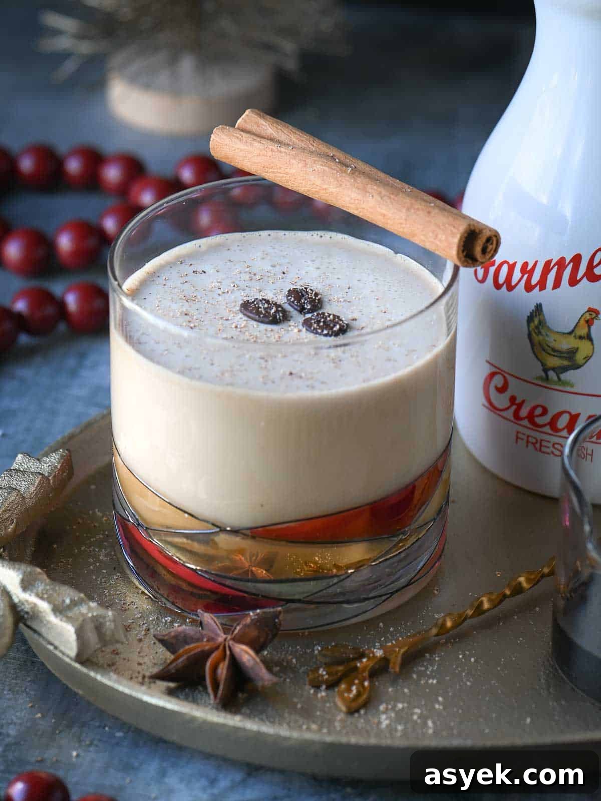 Festive Eggnog White Russian Cocktail Recipe 3 Close up of an eggnog White Russian drink in a clear glass garnished with coffee beans.