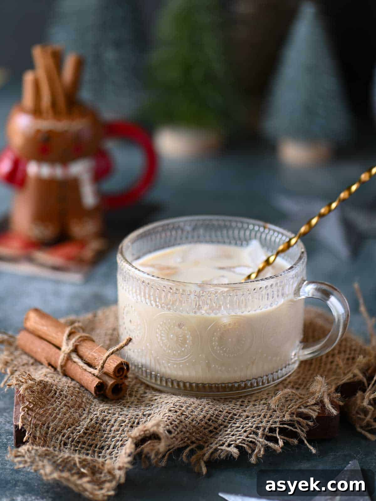 Festive Eggnog White Russian Cocktail Recipe 7 An eggnog white Russian in a clear class with a stirrer in it.