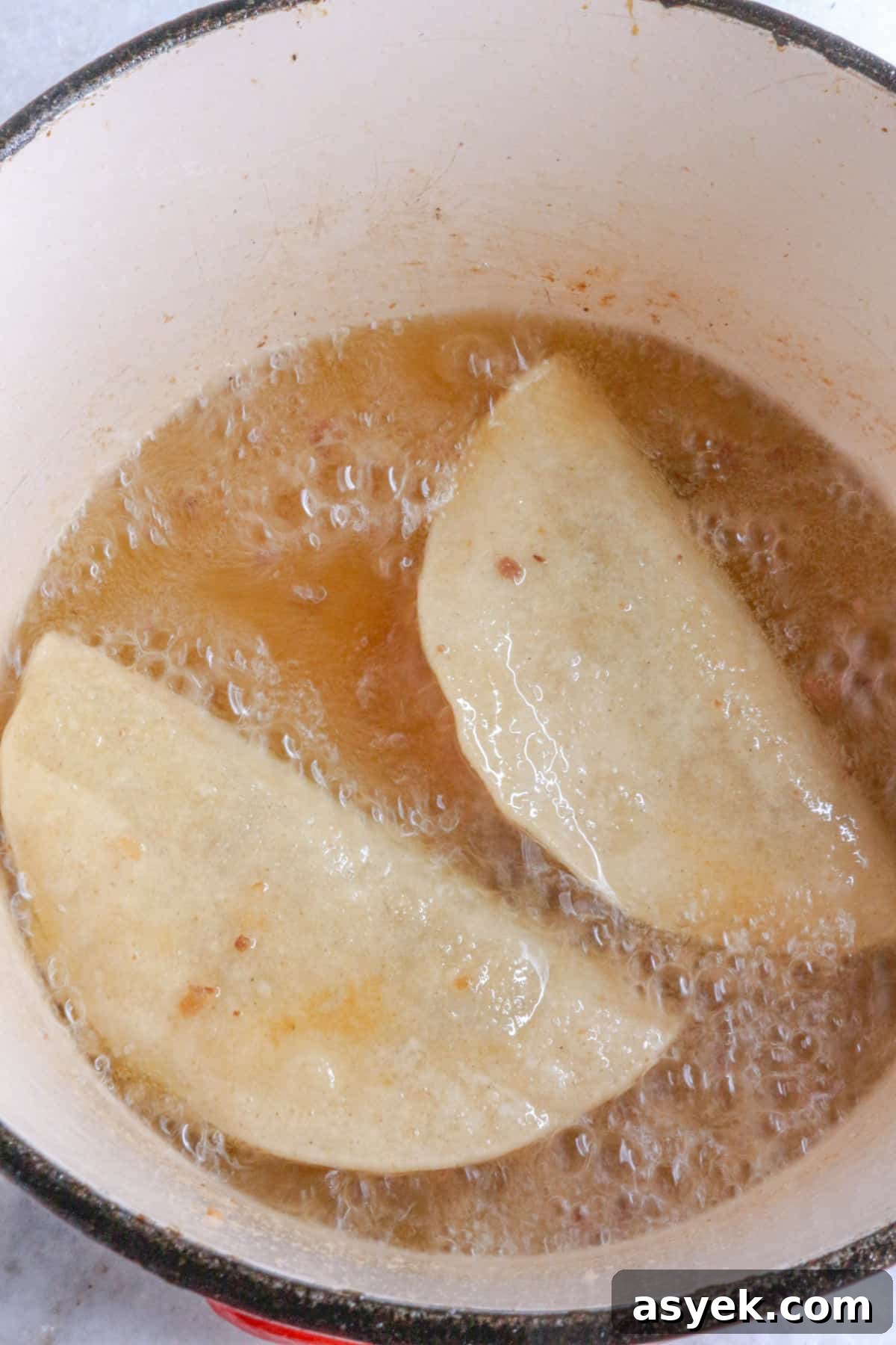 Crispy Mexican Bean Taco Recipe (Tacos Dorados) 7 Two bean tacos being fried in oil