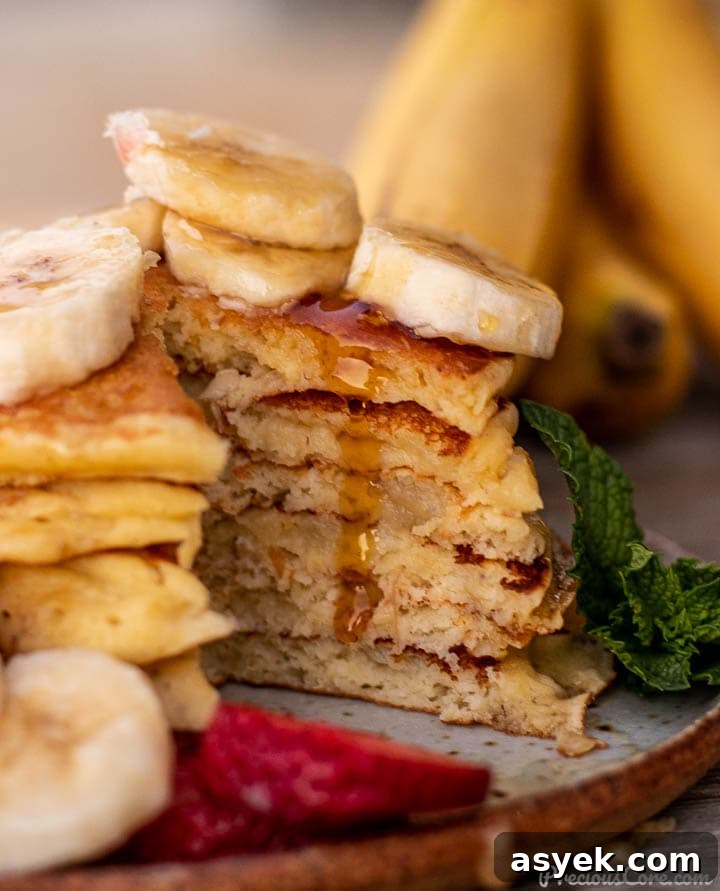 Banana Pancakes cut into with maple syrup dripping
