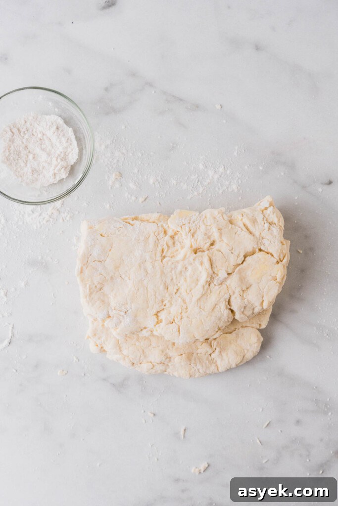 Buttery Air Fryer Biscuits in 15 Minutes 8 mixing and folding the dough on a floured surface.