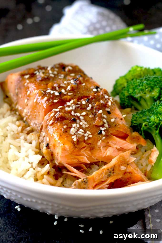 Oven-Baked Honey Ginger Glazed Salmon Recipe 6 Baked Salmon over rice on a white bowl.