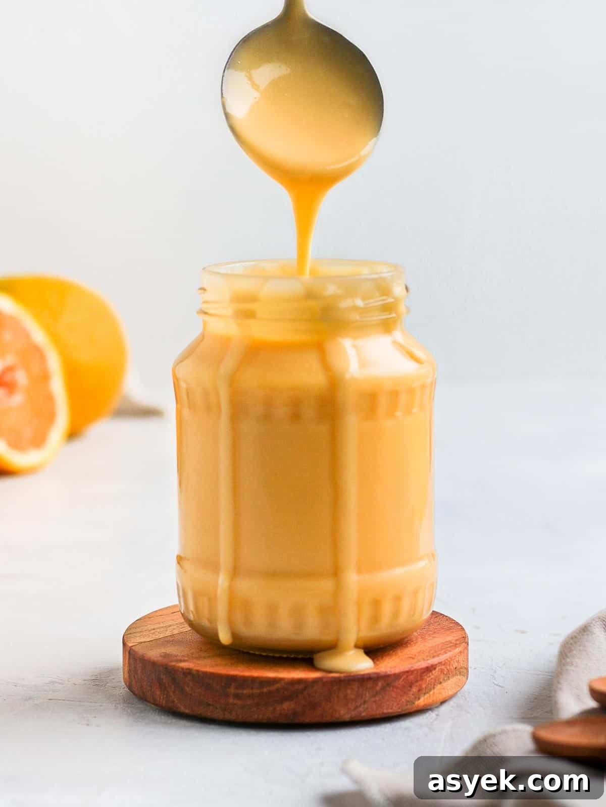 Curd dripping from a spoon into a glass jar