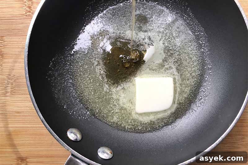 Horizontal image of a pan with melted butter and syrup pouring into the pan.