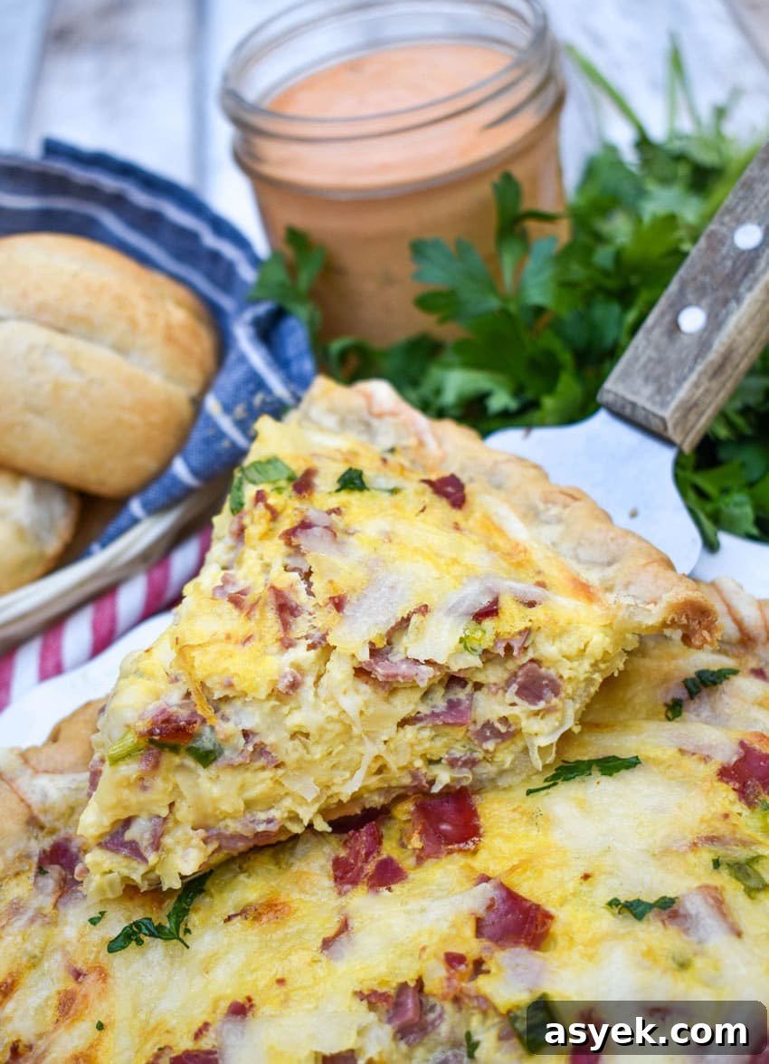 Reuben Quiche Recipe: Corned Beef, Swiss and Sauerkraut 5 a wooden handled pie server holding up a slice of reuben quiche