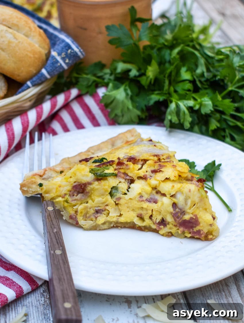 Reuben Quiche Recipe: Corned Beef, Swiss and Sauerkraut 6 a slice of a baked reuben quiche on a small white plate with a fork resting on the side