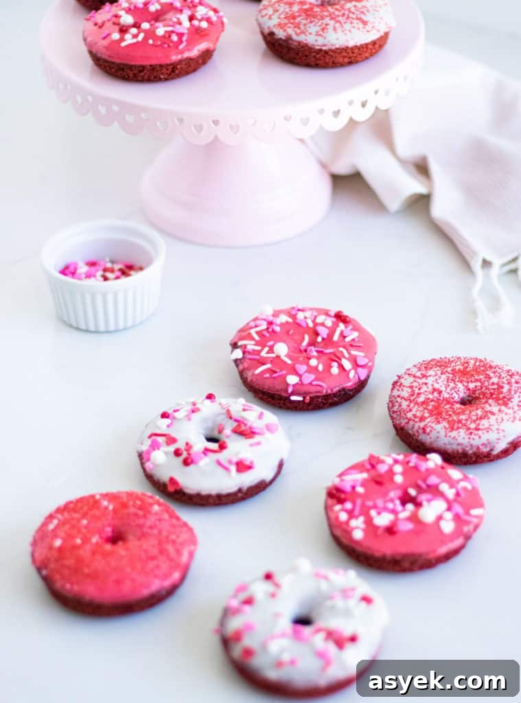 Homemade Red Velvet Baked Donuts with Cream Cheese Glaze 3 red and white donuts with sprinkles on a counter