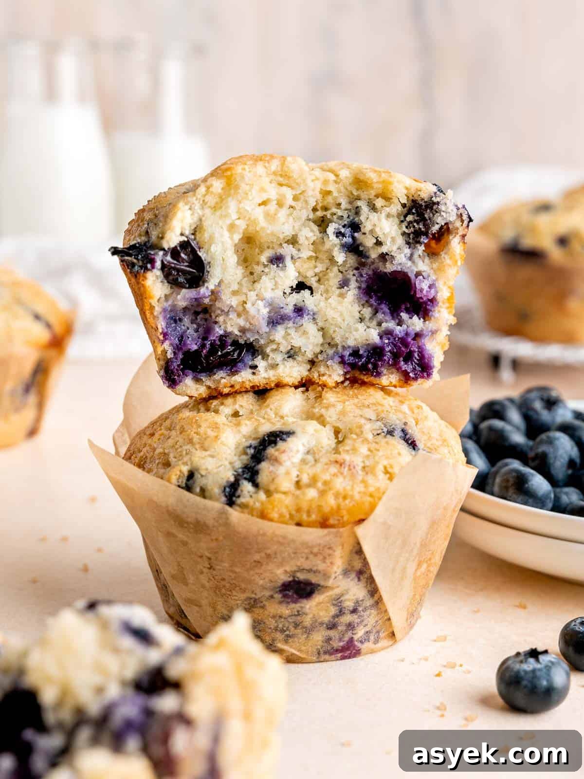 Half of a jumbo sourdough blueberry muffin stacked on a whole one.