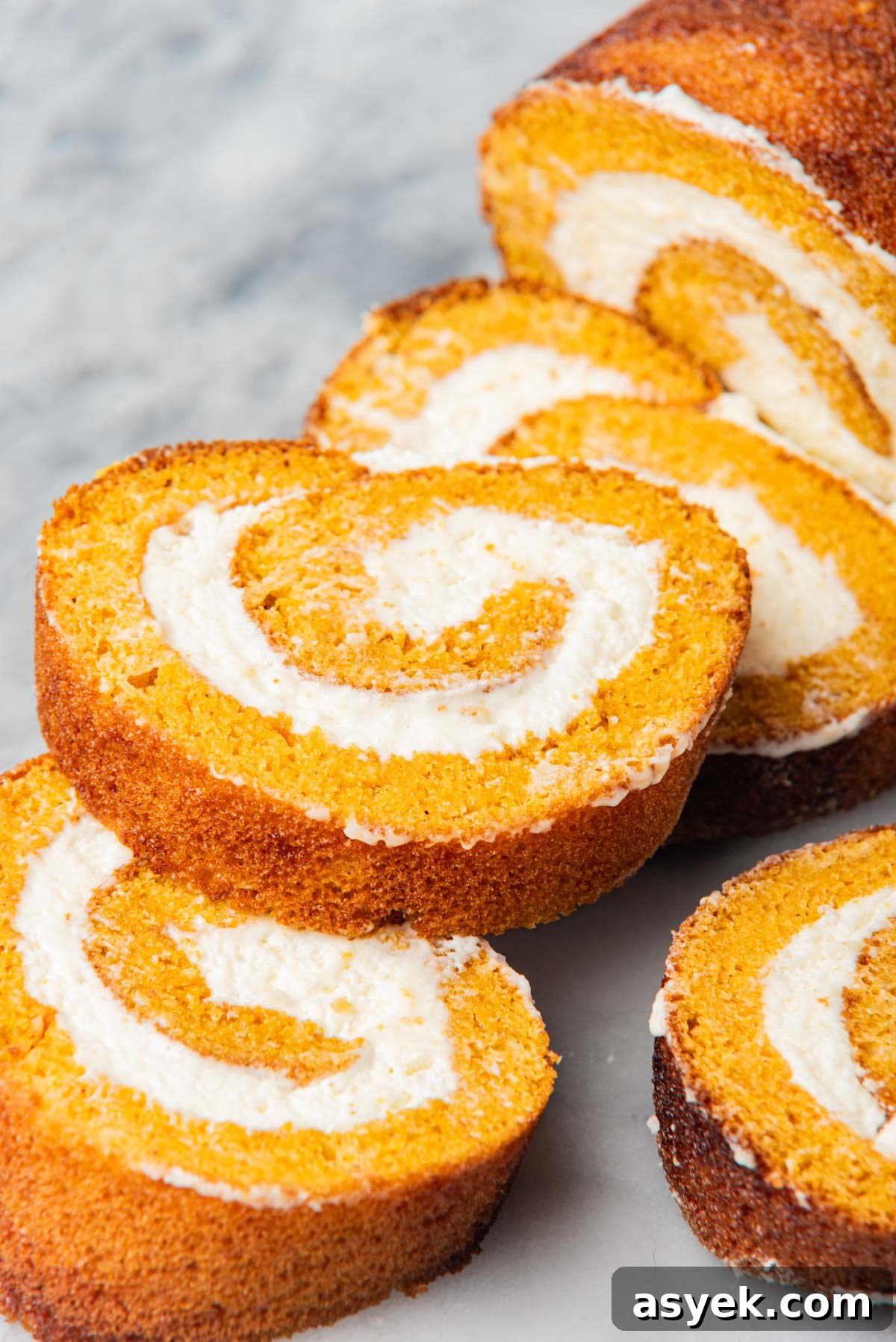 Slices of roll with cream cheese filling arranged on a marble surface.