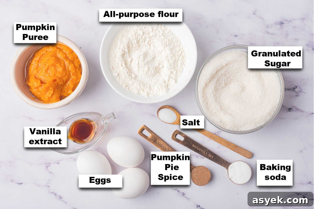 Ingredients for a pumpkin roll recipe laid out on a marble surface.