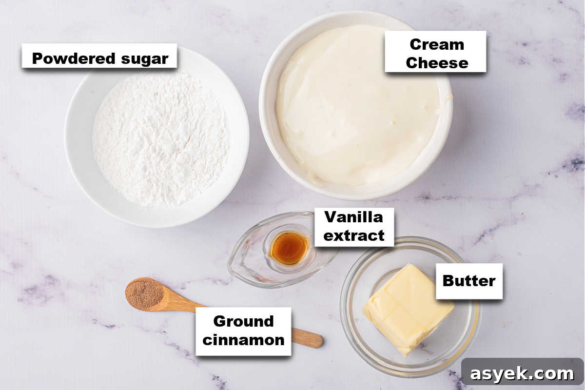 Ingredients for a pumpkin roll icing laid out on a marble surface.