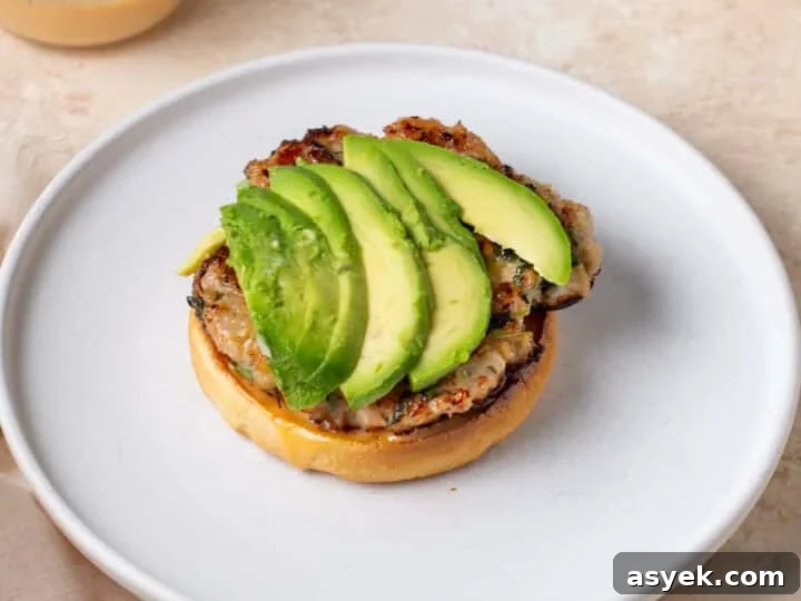 sliced avocado layered on top of a chicken patty