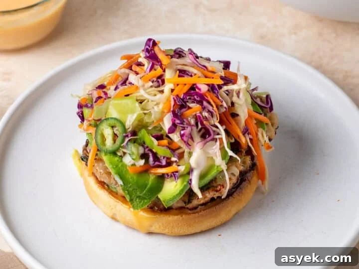 chicken burger topped with avocado and fresh sesame slaw