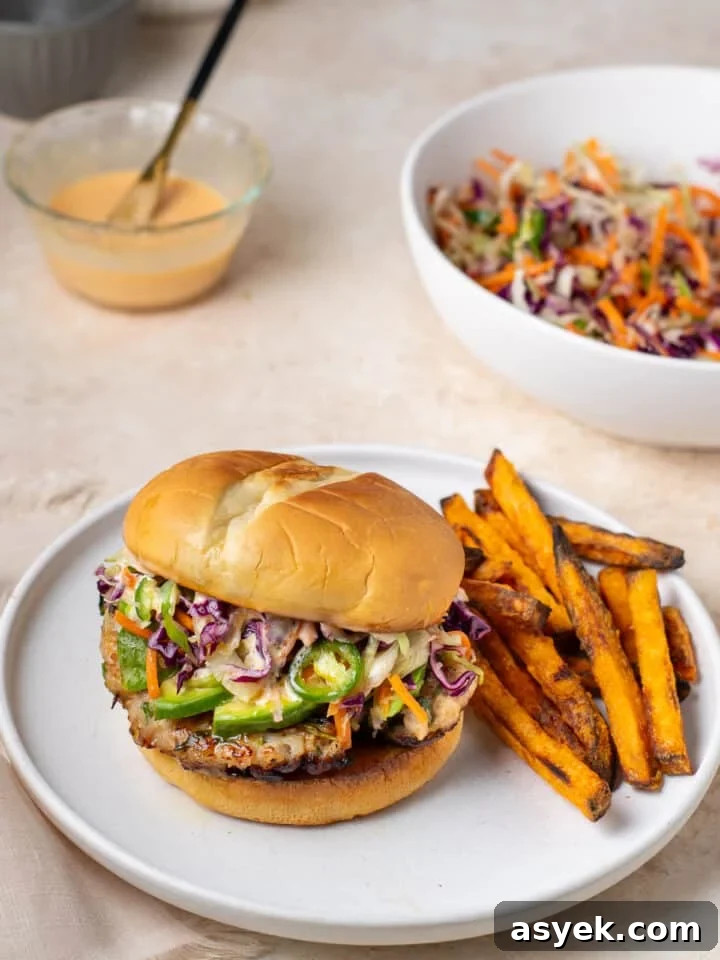sweet chili ground chicken burger with avocado slices, sesame slaw and sweet potato fries