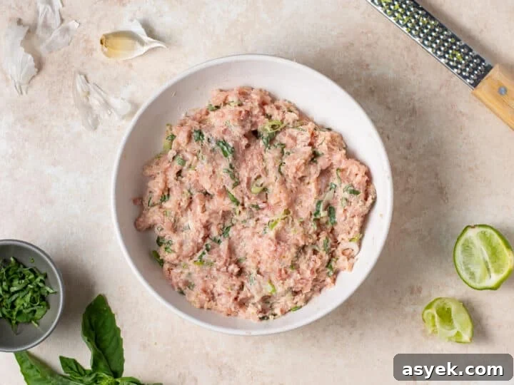ground chicken mixture fully combined with herbs and seasonings in a bowl