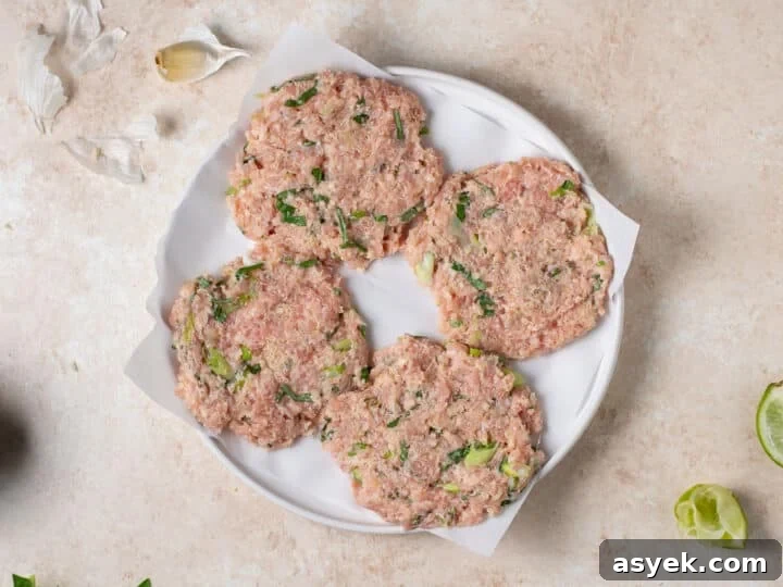 uncooked chicken patties shaped and placed on parchment paper
