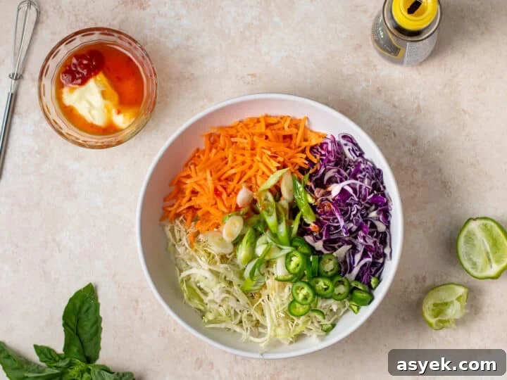 shredded cabbage, carrots, green onions and jalapeños in a bowl before mixing