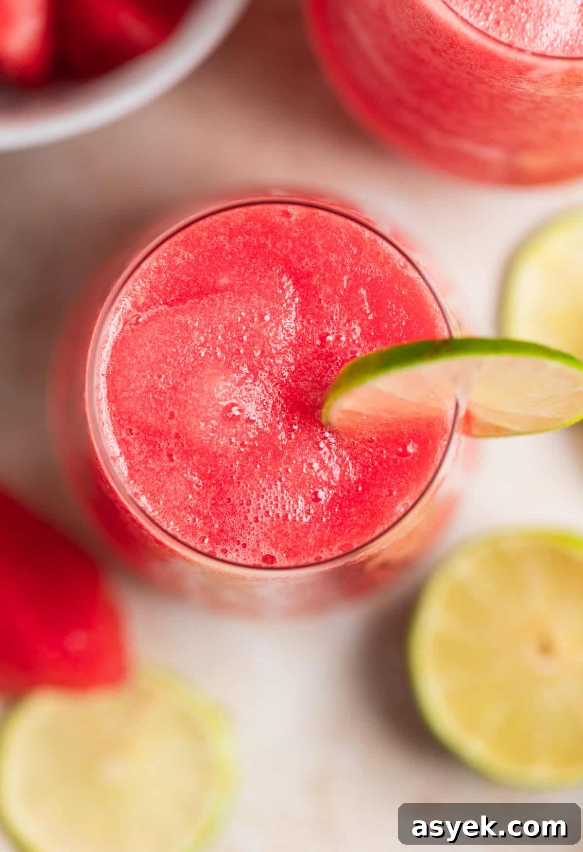 View inside wine glass with frozen watermelon rosé with a lime slice for garnish.