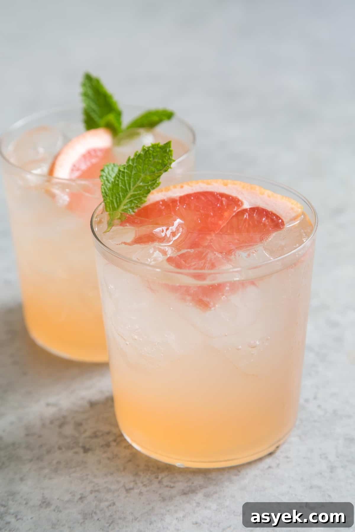 Grapefruit Cinzano cocktail garnished with grapefruit wedge and fresh mint.