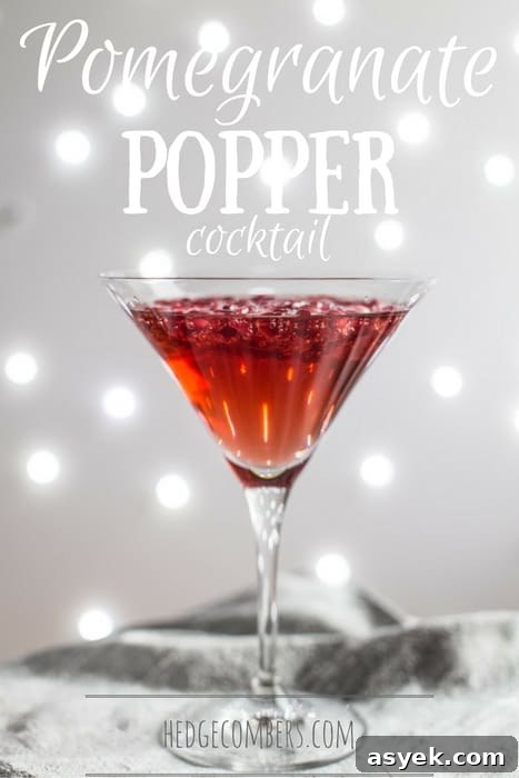 Sparkling Pomegranate Popper Cocktail Recipe 2 A cocktail glass of Pomegranate Popper Cocktail on a silver cloth