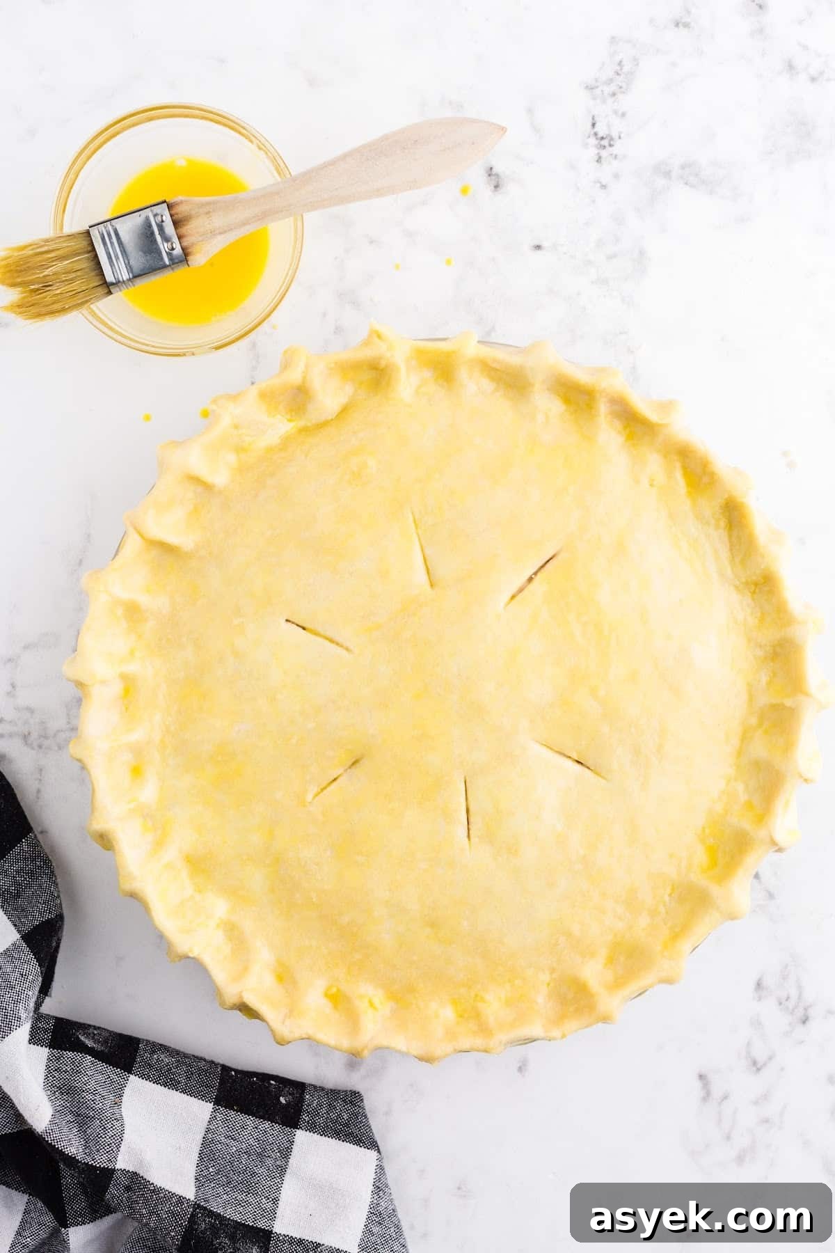 Brushing butter over the pot pie crust.