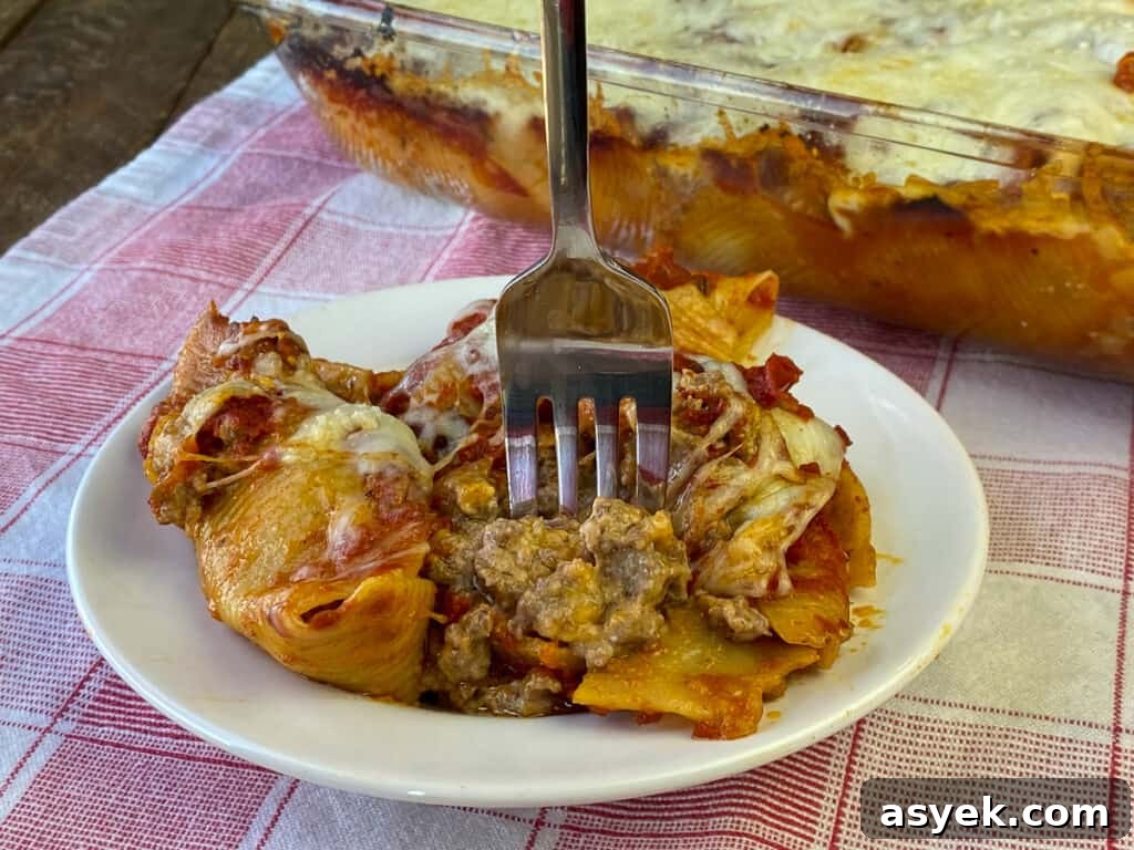 Fork full of easy beef stuffed shells on a white plate