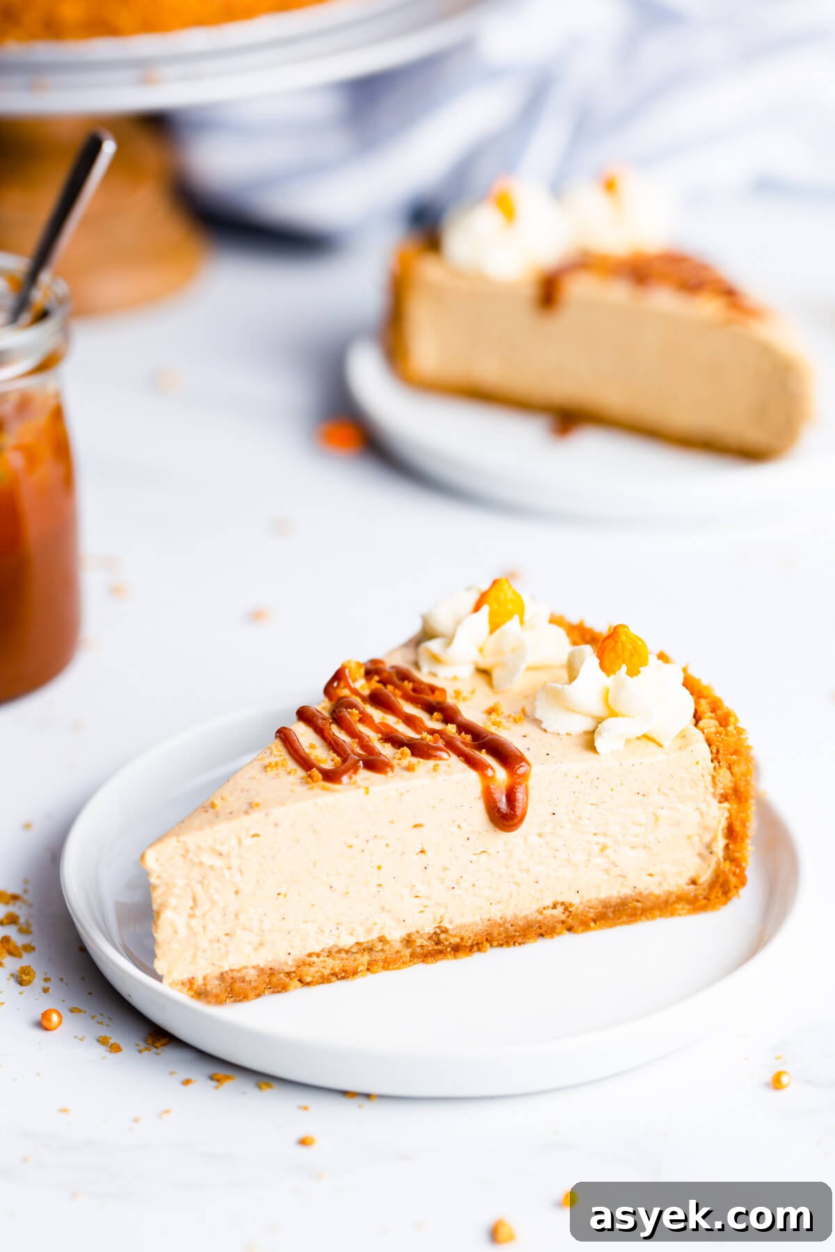 Creamy No-Bake Pumpkin Cheesecake Recipe 11 45 degree angle super close up at a single slice of pumpkin cheesecake drizzled with salted caramel