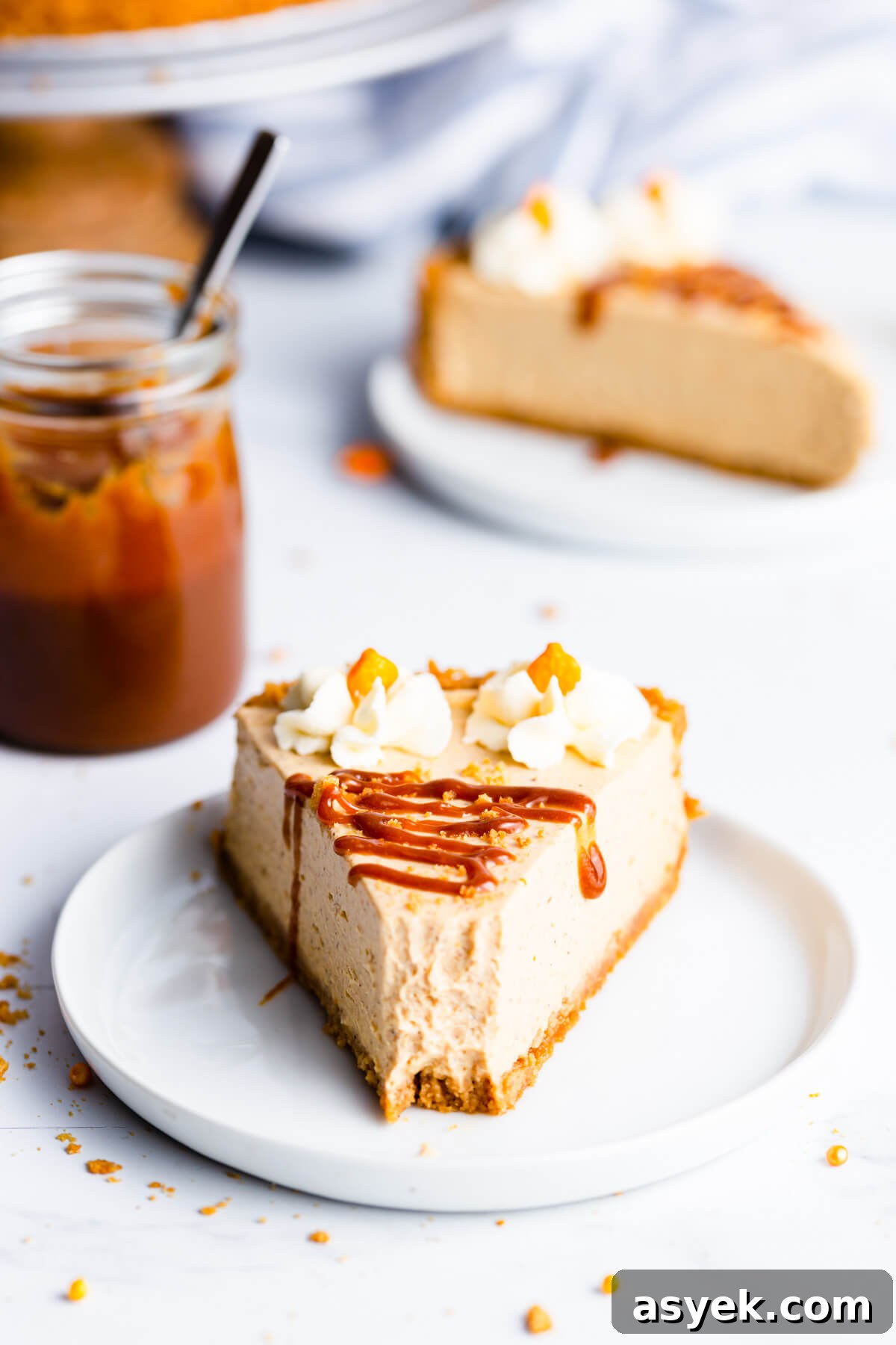 Creamy No-Bake Pumpkin Cheesecake Recipe 13 straight ahead super close up at a single slice of pumpkin cheesecake drizzled with caramel sauce