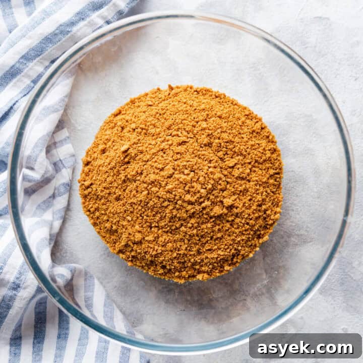 Creamy No-Bake Pumpkin Cheesecake Recipe 5 overhead view of a glass bowl with biscuits crumbs