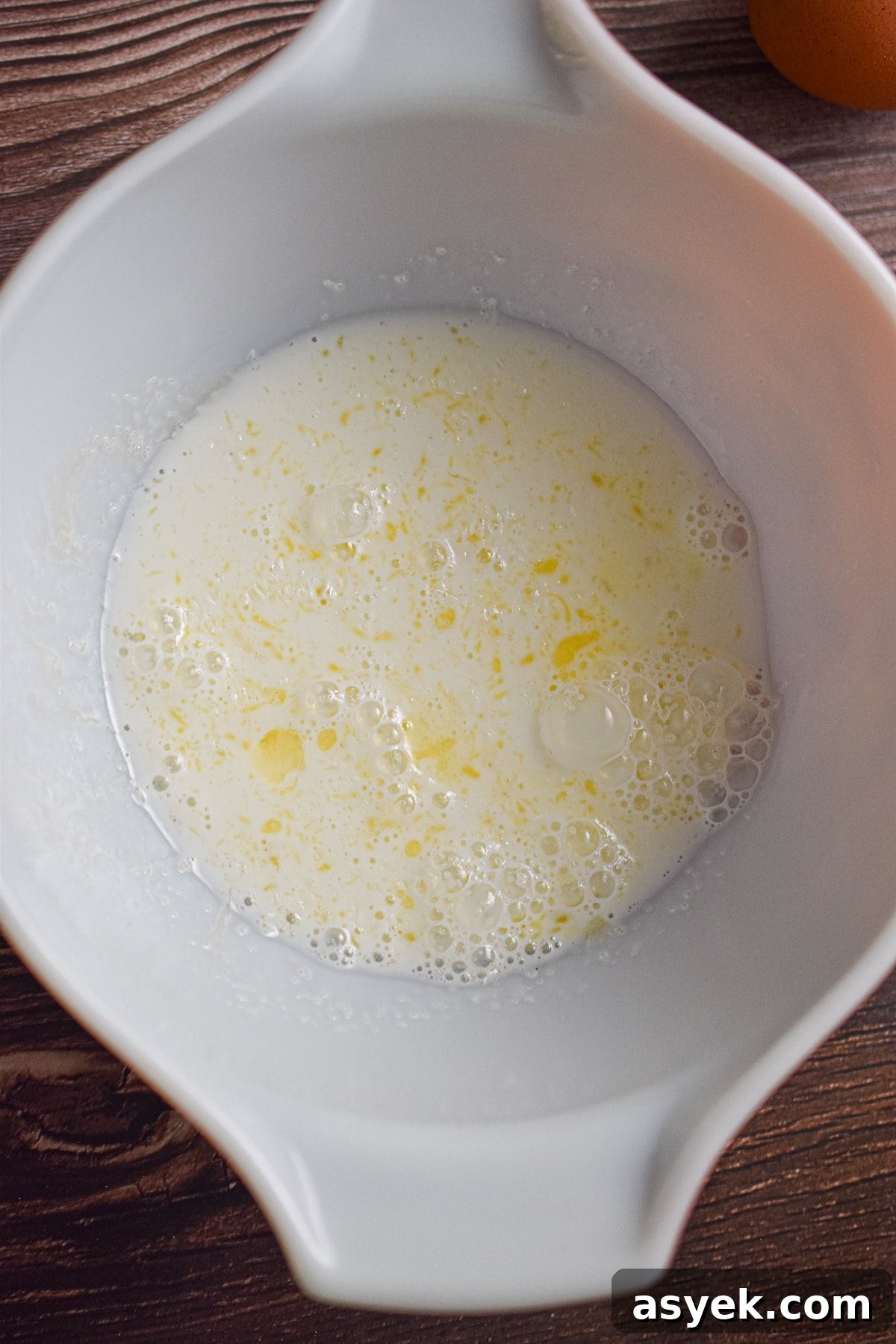 The milk, sugar, and melted butter are mixed together in a large bowl.