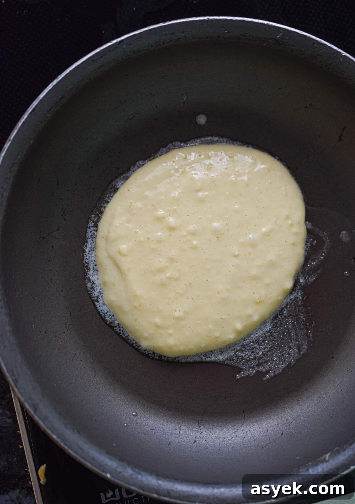 The pancake batter is in a large skillet.
