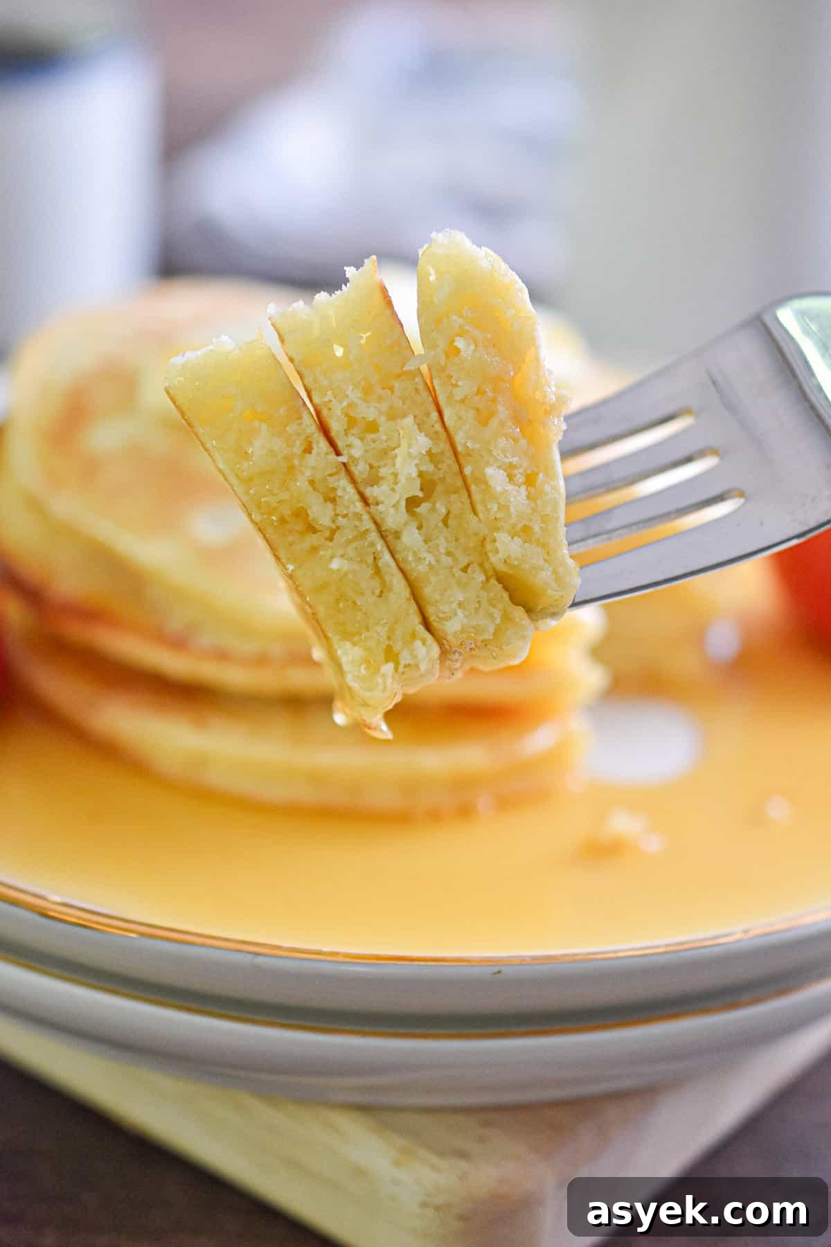 A slice of the pancakes is being held by a fork.