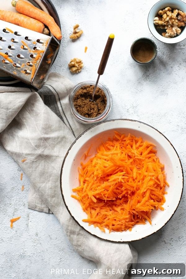 Simple ingredients for keto carrot cake on a white surface.