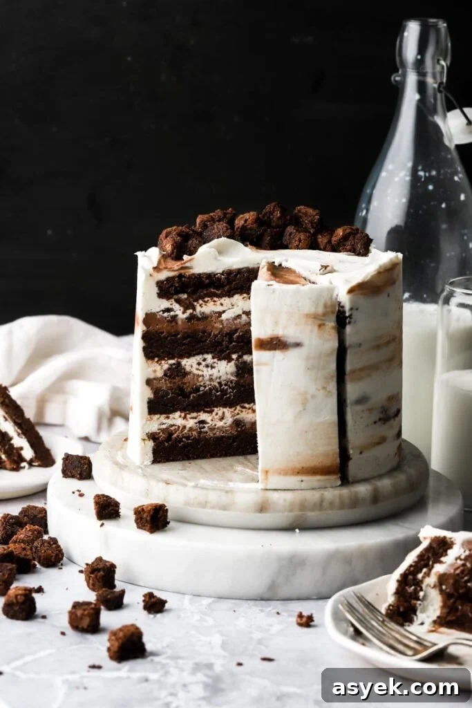 Fudgy Chocolate Brownie Cake Recipe 2 brownie cake frosted with cream cheese frosting, a slice removed and little brownies and milk on the side