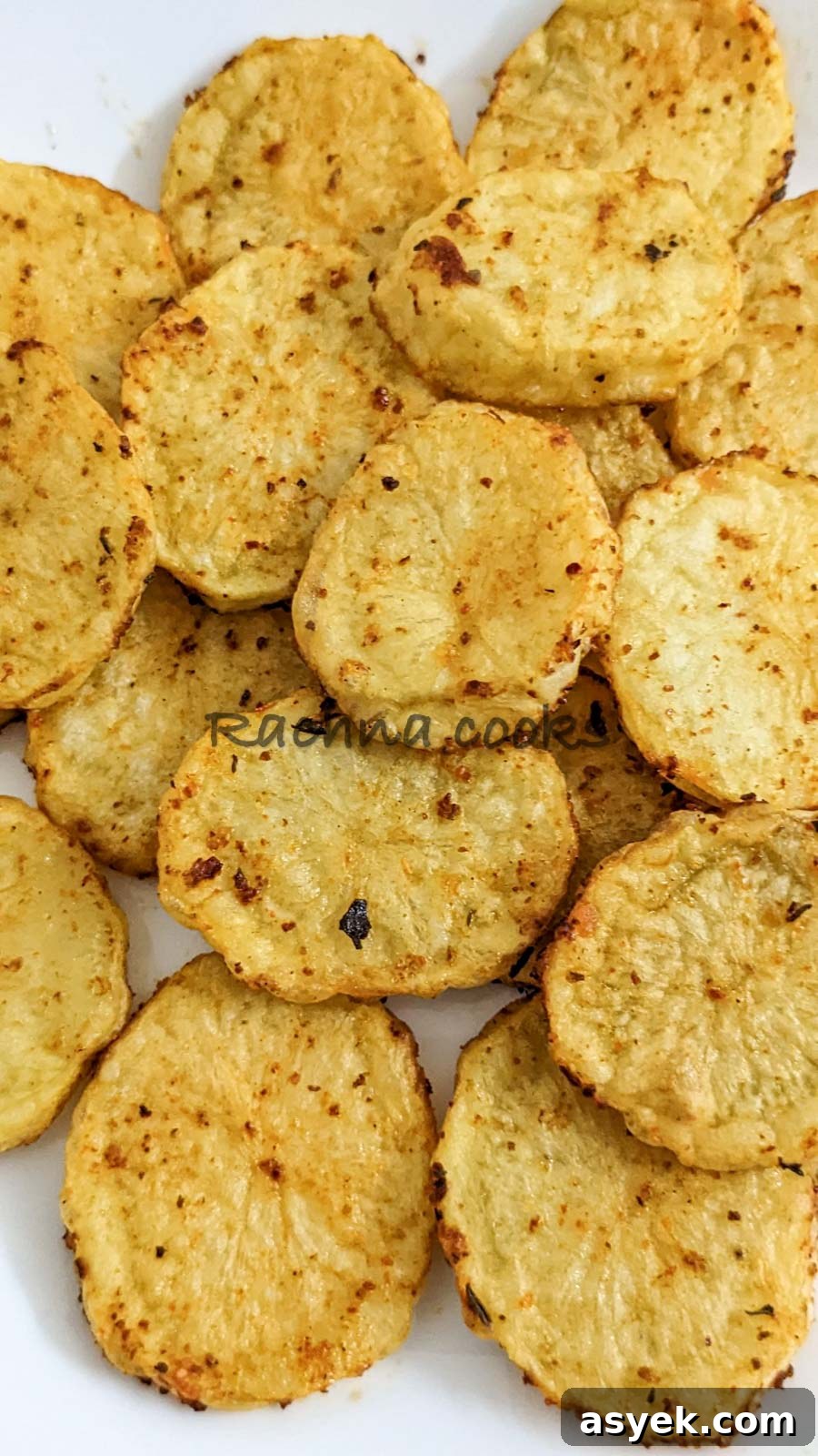 Crispy Air Fryer Potato Slices 11 Close up of Air fried potato slices on a white plate.