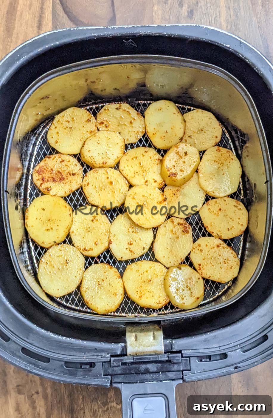 Crispy Air Fryer Potato Slices 8 Potato slices in air fryer basket for cooking.