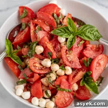 Tomato Basil Salad with mozzarella in a white bowl.