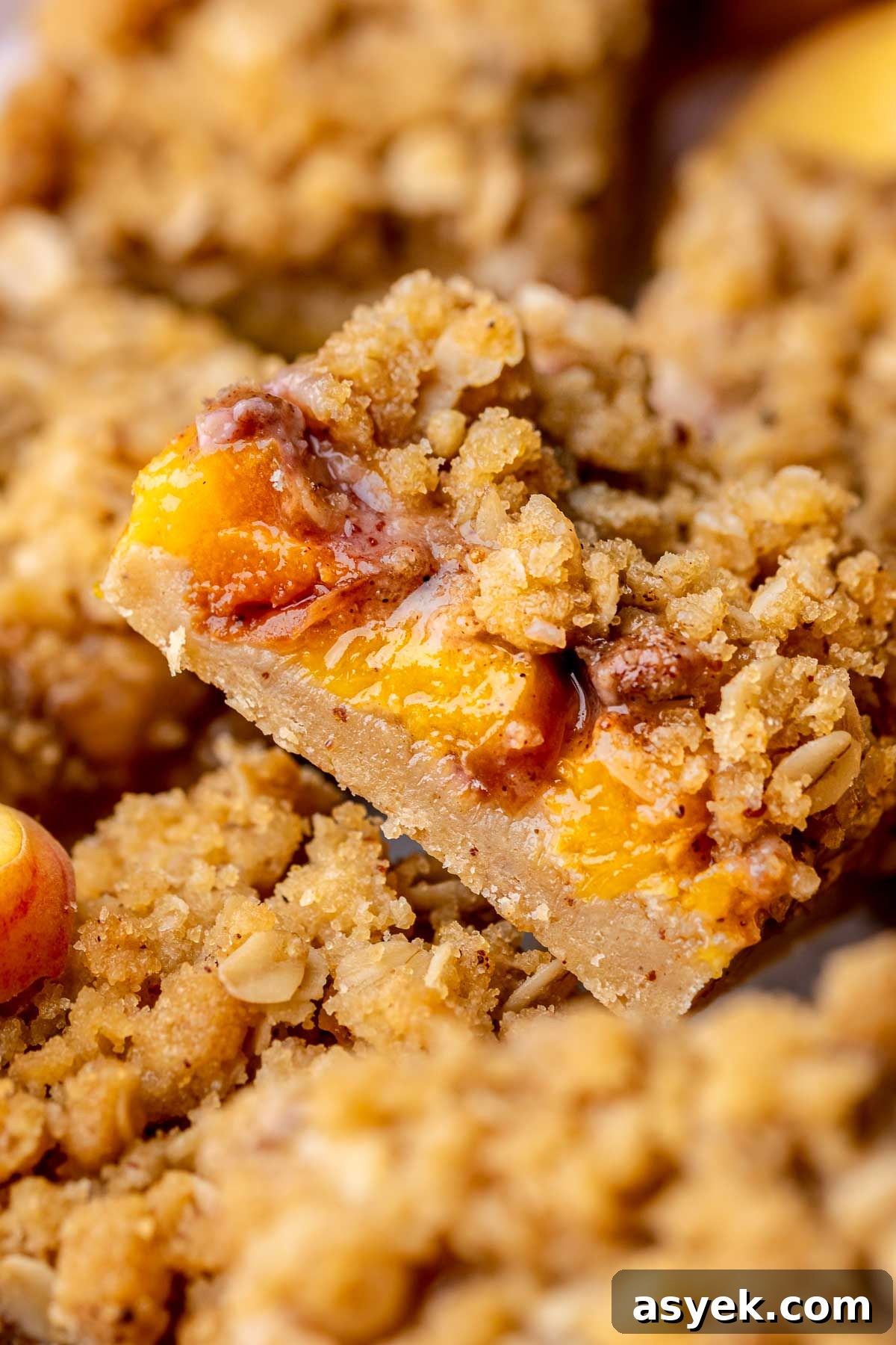 Brown Butter Peach Crumble Bars Recipe 2 A slice of peach crumble bars sliced laying on its side.